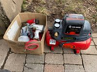 King Canada oil-free air compressor with tools in a cardboard box outdoors on patio ground