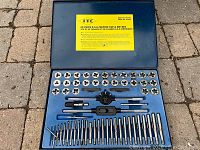 Full view of open blue case containing 60 piece tap and die set including metal dies, taps, and handles.