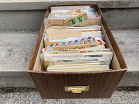 Wooden box filled with multiple rows of postal covers and envelopes.
