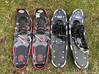 Two pairs of snowshoes on grass, showing overall design and condition.
