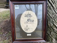 Full view of framed artwork showing two oval pen and ink drawings by Charles Shackleton.