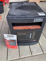 Full front view of EdenPURE quartz infrared heater with control panel and wood-tone detail, manual placed in front on a wooden deck.