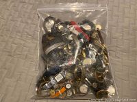 Full view of large clear plastic bag filled with numerous wristwatches