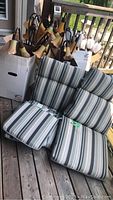 Photo showing striped cushions and two boxes filled with garden solar lanterns, some with petal shaped tops