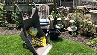 Wide shot showing garden cart, resin chair with cushion, spade, bird feeders and plant trays