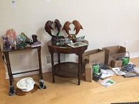 Overview of two tables showing figurines, mineral specimens and steamers with packing boxes