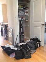 Photo showing Shark vacuum with multiple accessories laid on the floor with mesh basket and other items behind.