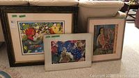 Three framed artworks grouped together showing varied styles and sizes.