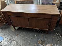 Full front view of the Kroehler mid-century modern credenza showing rectangular shape, two drawers on top, and two sliding doors below with round knobs. Wood surface with visible wear.