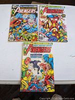 Three Avengers comic books laid out on a flat surface showing front covers.
