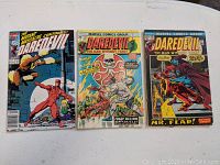 Three Daredevil comic books (#91, #121, #238) laid out side by side showing front covers with colorful artwork and titles.
