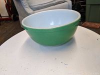 Side view of the green and white Pyrex mixing bowl showing its shape and condition.