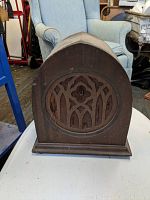Front view of the antique Peerless external speaker showing cathedral style wooden case with decorative grille.