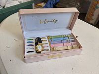 Overview of the complete Infinity women's wristwatch set including watch, bands, and bezels with pink storage case.