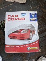 Front of the Budge car cover box showing size 4 for full size cars, single layer, double stitched seams and elastic hem features along with a 2 year warranty.