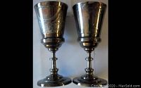 Two silverplated chalices side by side showing different engraved designs and overall shape and condition.