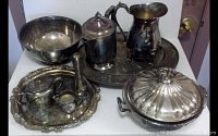 Full view of all silverplate pieces including bowl, pitchers, trays, and covered casserole.