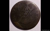 Obverse side of the 1775 British half penny coin showing a worn profile bust and the large die break near the date area.