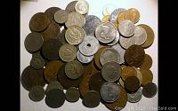 Top view of assorted foreign coins showing varied sizes and metals including silver and copper tones.