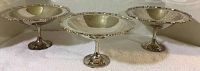 Three silver plated compotes with pedestal bases, viewed from the front.