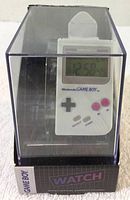Angled front inside box view showing digital watch face and button details with Nintendo Game Boy logo on watch.