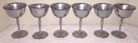 Six metal goblets arranged in a row showing the full front view of each.