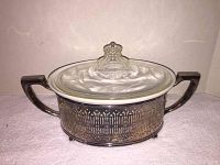 Oval glass casserole dish with floral etched lid inside silverplate metal holder with handles shown from side