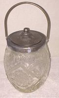 Front angled view showing the embossed glass pattern, metal handle, and lid on biscuit jar.