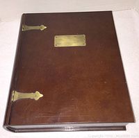 Closed wooden case with brass hinges and brass plate on front cover, showing some scratches and polished wood finish.