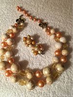 Full view of two-strand vintage choker necklace with large marbled beads, peach pearl-like beads and yellow faceted beads alongside matching cluster clip-on earrings.