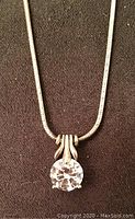 Close-up view of the round cubic zirconia solitaire stone pendant on a sterling silver chain.