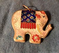 Front view of the elephant-shaped cloisonné pendant with colorful enamel decoration showing red, blue, white, and green floral and geometric patterns