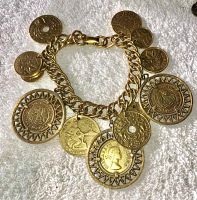 Front overall view of gold-tone coin charm bracelet with multiple coin-like charms on chain with Coronation clasp.