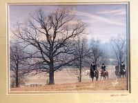 Framed signed photograph showing four riders on English horses in a rural fall or winter scene with large leafless trees and soft sky, focusing on the art and signature.
