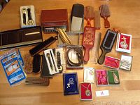 Full overview of the lot on table including watches, wallet, belt, brushes, tie clips, mechanical pencils, cases, and some jewelry.