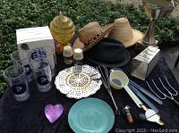 Overall view of lot contents showing hats, glass feeder, kitchen items, tumblers and accessories