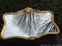 Front view of the Ethan Allen gold framed mirror with ornate carved design and reflective glass surface.