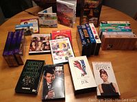 Overview photo showing multiple DVDs, Wii games, and VHS movies laid out on a table