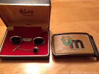 Photo of black onyx cufflinks and tie tack in McCurdy's box and UM Coop leather belt buckle.