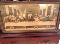 Framed print of The Last Supper showing entire scene and carved wood frame.