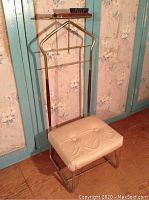 Full view of the vintage gentleman's valet stand showing chrome metal frame, padded seat, leather straps, and small shelf with brush.