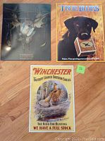 Set of three metal poster tin signs laid out on floor showing all design fronts