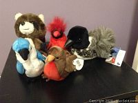 Front view of the group of five plush animals including three Ty Beanie Baby birds, Loon named Lottie, and Daskin raccoon