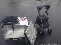 Photo showing two foldable wire dog crates with trays, black travel bag, leash and collar on a white towel, and Outward Hound dog stroller.