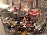 Photo showing multiple crafting supplies on wire shelving including adult coloring books, glue sticks, and various tools in containers