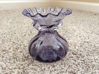 Front view of the amethyst glass vase showing its ruffled top edge and decorative waist.