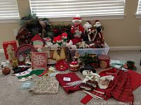 Overall lot showing multiple Christmas decorations including Santa and snowmen plush figures, wreaths, red and green textiles, and assorted small holiday decor.