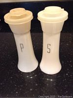 Pair of vintage white Tupperware salt and pepper shakers with lids marked S and P