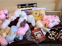 Assorted skeins of yarn and crafting supplies on a table