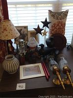Full lot overview showing lamp, birds, buildings, vase, sconces, frames, candles, and lantern shade